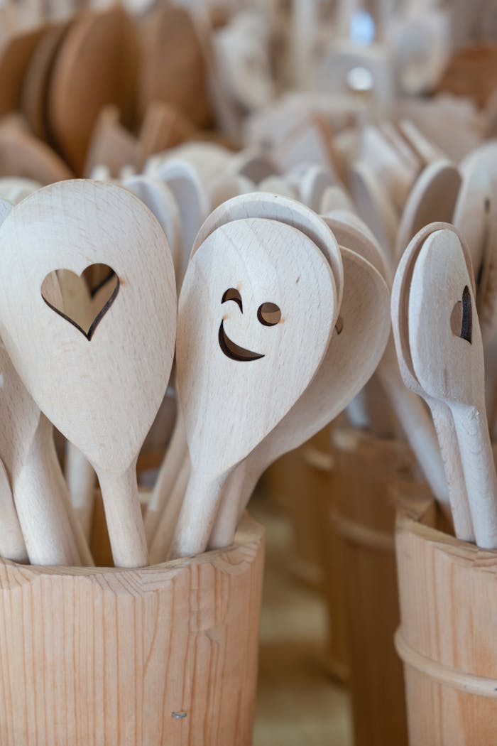 Charming handcrafted wooden cooking spoons featuring heart and smile cutouts in a wooden holder.