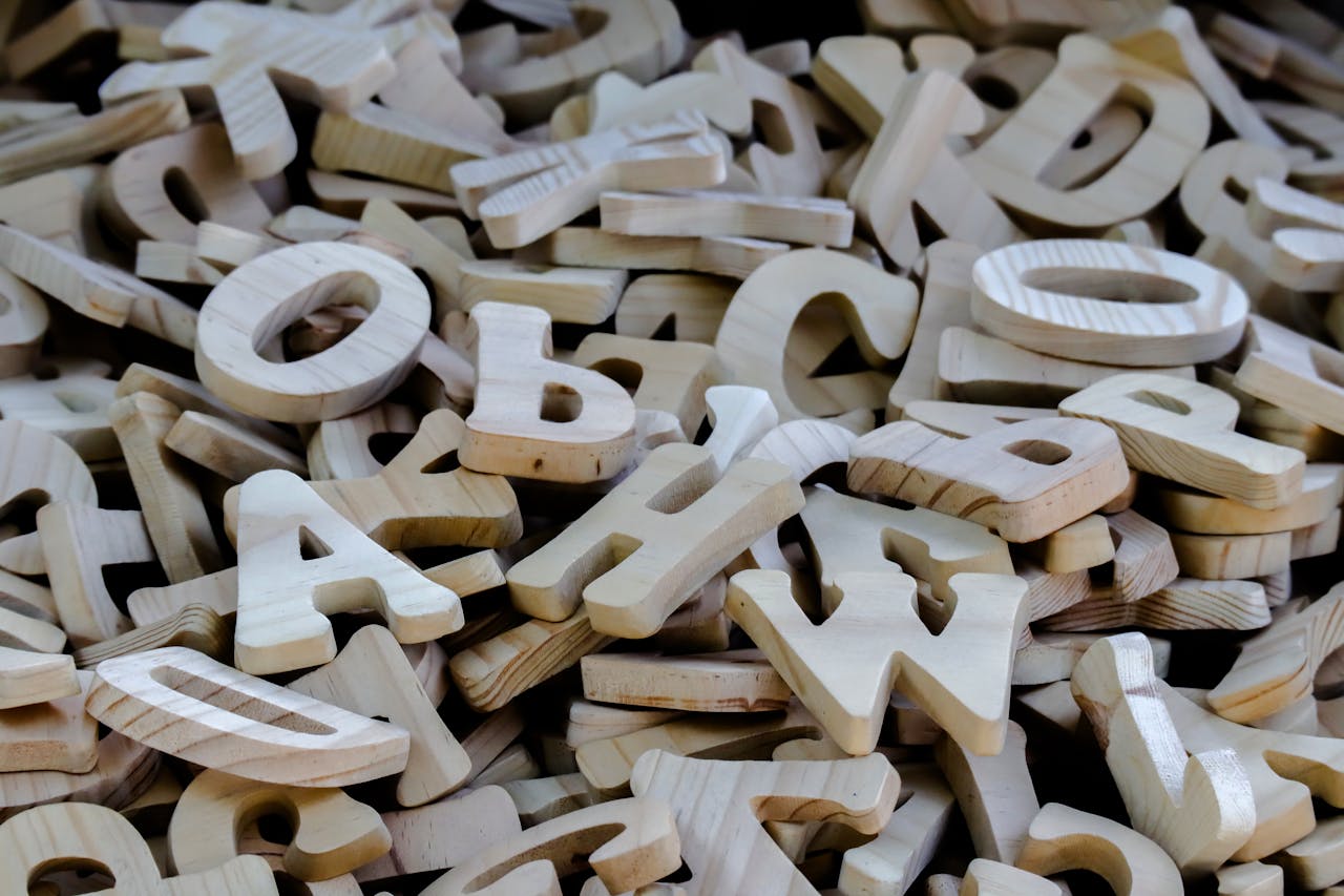 A collection of wooden alphabet letters suitable for crafting, education, and decoration.